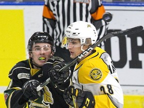 London Knight Liam Foudy reaches the puck while being tangled up by Kelton Hatcher of the the Sarnia Sting in London on Monday. (Derek Ruttan/The London Free Press)