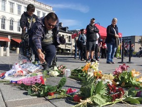 William Nakogee from the Kashechewan First Nation sprinkles tobacco in Springer Market Square to honour The Tragically Hip lead signer Gord Downie, who died in October. (Elliot Ferguson/Whig-Standard file photo)