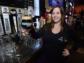 Christina Hopeson, a bartender/manager at Toboggan Brewing Company holds a glass of their new chocolate orange stout. (MORRIS LAMONT, The London Free Press)