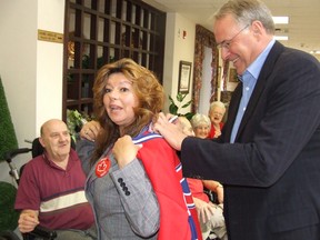 Louise Portelance helps former NHL goalie and Liberal MP Ken Dryden sign a Canadiens jersey for Gerald Martin, left, a resident at the Elizabeth Centre in Val Caron. Dryden was in Nickel Belt to help boost Portelance's campaign to represent the riding federally in 2008. (Rachel Punch/Sudbury Star file photo)