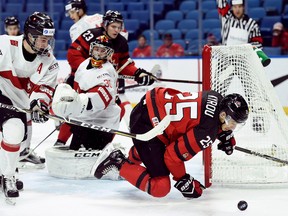 Canada's Jordan Kyrou (25) of the Sarnia Sting reaches for the puck after being shoved by Switzerland's Nico Gross (16) during the first period in a quarter-final at the world junior hockey championship in Buffalo, N.Y., on Tuesday, Jan. 2, 2018. Kyrou had a goal and an assist in an 8-2 win. (NATHAN DENETTE/The Canadian Press)