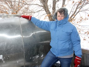 Jessica Brooks, who has had issues with her water well, is shown with her frozen tank on Tuesday.
