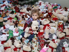 Razan Ellawindy, two years old, sits among almost 300 stockings and teddy bears at the Kingston Community Health Centres in December. For the fourth year, Mary Campeau, a longtime real estate broker with Royal Lepage Pro Alliance Realty, spearheaded a program that has created more than 300 stockings stuffed with toys and soft stuffed animals for the children of clients served by KCHC. (Ian MacAlpine/Whig-Standard file photo)