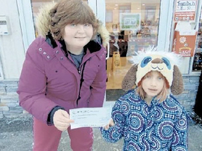 Submitted Photo
Carly Land, 12, and Payton Oliver, 8, hold a donation cheque for the Children's Cancer Fund at Kingston General Hospital while standing in front of the Shannonville-based business Fast Freddy's. The business was one of several in the area that helped Land raise the funds.