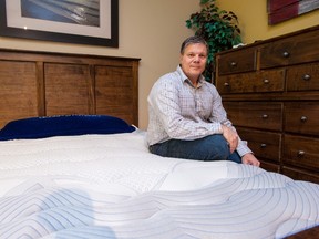 Mike Cleaver sits on a new waterbed at his mattress store, Waterbed Gallery, in Barrie.  (Stephan Potopnyk/THE CANADIAN PRESS)