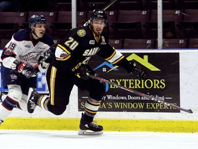 Sarnia Sting's Connor Schlichting (20) is chased by Saginaw Spirit's Blade Jenkins (19) in the second period at Progressive Auto Sales Arena in Sarnia, Ont., on Wednesday, Jan. 3, 2018. (MARK MALONE/Postmedia Network)