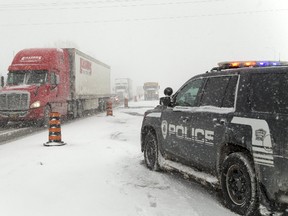 An Oneida police truck sits on the westbound lanes of the 402 as traffic is routed onto Highway 2 just west of Delaware west of London, Ont. on Thursday January 4, 2018 due to heavy snowfall. (MIKE HENSEN, The London Free Press)