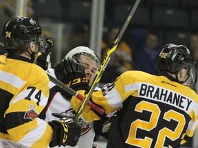 Kingston Frontenacs defenceman Sean Day roughs up Windsor Spitfires Luke Boka with some help from teammate Jakob Brahaney during the first period of Ontario Hockey League action at the Rogers K-Rock Centre in Kingston. Day is close to returning to the Kingston lineup. (Steph Crosier/The Whig-Standard)