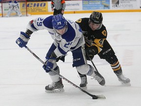 Darian Pilon, left, of the Sudbury Wolves, and Ryan Moore, of the Hamilton Bulldogs, battle for the puck during OHL action at the Sudbury Community Arena in Sudbury, Ont. on Friday December 15, 2017. John Lappa/Sudbury Star/Postmedia Network