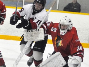 Mitchell Hawks’ goalie Curtis Laviolette (30) is bumped out of his crease by Walkerton Hawks’ Justin Donnelly (15) during PJHL Pollock division action last Wednesday, Jan. 3 in Mitchell. A shorthanded home side lost 8-2, snapping their five-game win streak, but they rebounded with a 6-4 win in Hanover last Friday, Jan. 6. ANDY BADER/MITCHELL ADVOCATE