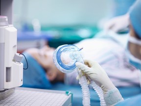 Nurse holding anesthesia mask in operating room (Getty Images)