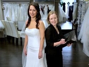 Model Kori Marques wears a fitted, strapless silk Mikado gown by Allure for $1,325. She is also wearing a cathedral length veil by Allin Rae for $375. With her is wedding planner Amy McNall, on location at Sophie's Gown Shoppe. (MORRIS LAMONT, The London Free Press)