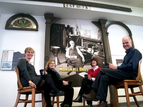 Nancy Collister, the London Public Library’s director of customer services and branch operations (left), Dorothy Palmer and Sharon Lunau from ACO London, and Mike Baker, formerly of Museum London, sit next to the Marshall Bros. and Co. façade recently installed at the Central Library downtown. (CHRIS MONTANINI, Londoner)