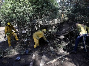 Firefighters clear debris from a mudslide as they try to fix a gas leak on January 10, 2018 in Montecito, California. (Photo by Justin Sullivan/Getty Images)