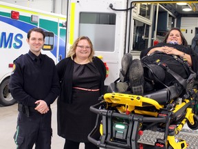 Deputy Premier Sarah Hoffman (Centre) joins Stony Plain MLA Erin Babcock (right) during a tour and demonstration of new power stretcher equipment at the Stony Plain/Parkland EMS building.