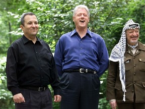 STEPHEN JAFFE/Getty Images
Then Israeli Prime Minister Ehud Barak, from left, U.S. President Bill Clinton and Palestinian leader Yasser Arafat pose for a photograph at Laurel Cabin, the site where former Egyptian president Anwar Sadat, former Israeli prime minister Menachem Begin and former U.S. president Jimmy Carter conducted peace talks in 1978, during the Middle East Peace Summit on July 11, 2000, at Camp David, Maryland, the U.S. presidential mountain-top retreat.