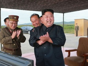 In this undated file photo distributed on Saturday, Sept. 16, 2017, by the North Korean government, North Korean leader Kim Jong Un, center, celebrates what was said to be the test launch of an intermediate range Hwasong-12 missile at an undisclosed location in North Korea. Korean Central News Agency / Korea News Service via AP