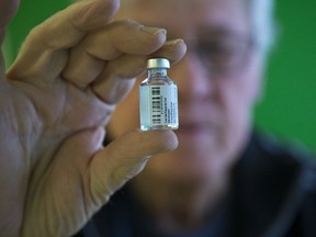 Gerald Chaplick, a pharmacist at Turner Drugs in London, holds a vial of influenza vaccine.  (DEREK RUTTAN, The London Free Press)