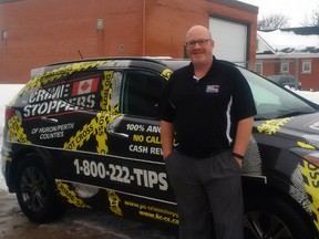 Const. Shawn McFalls, the program co-ordinator for Crime Stoppers in Perth County, stands next to the wrapped vehicle. Crime Stoppers was first introduced to Perth County 30 years ago. (Handout)