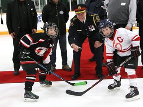 Zachary Guthrie, left, of the Long Lake Thunder, Greater Sudbury Police Chief Paul Pedersen and Alexandre Reynolds, of Cedar Park,  participate in the official puck drop for the annual Police Cup hockey tournament at the Gerry McCrory Countryside Sports Complex in Sudbury, Ont. on Friday January 12, 2018. John Lappa/Sudbury Star/Postmedia Network