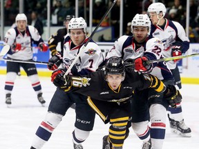 Sarnia Sting's Jordan Ernst (16) squeezes between Windsor Spitfires' Tyler Angle (7) and Thomas Stevenson (22) in the first period at Progressive Auto Sales Arena in Sarnia, Ont., on Friday, Jan. 12, 2018. (Mark Malone/Postmedia Network)