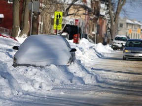 A car is severely snowed in on Barrie Street in Kingston on Sunday, despite winter parking regulations in effect until March 31, prohibiting on-street parking from 1 to 7 a.m. for most of the city. Fines for overnight parking during the winter months are between $25 and $30. (Steph Crosier/The Whig-Standard/Postmedia Network)