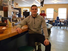 Michael Duciaume sits in his parents' restaurant, The McIntyre Coffee Shop. He said they've chosen to raise prices on the menu instead of laying off staff. Duciaume said he's hoping people support local businesses now more than ever.