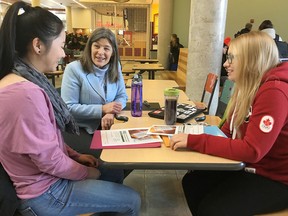 Kingston and the Islands MPP Sophie Kiwala, centre, talks about the province’s new OHIP+ program with Queen’s University students Janelle Tam, left, and Samantha Moore on Monday. (Elliot Ferguson/The Whig-Standard)