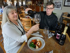 Bourbon Street Cajun and Creole Kitchen owner and chef Dominic (Mike) Raso pours a glass of wine for Barb De Jonge, sales manager and certified master taster for Coopers Hawk Vineyards. (MORRIS LAMONT, The London Free Press)