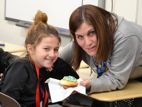 St. David School educational assistant Brenda Jack shares a cupcake with Grade 5/6 student Katelynn Michauville last year. The school marked National Cupcake Day by baking more than 230 cupcakes for staff and students, while simultaneously raising funds for the SPCA and awareness around animal welfare issues. (Sudbury Star file photo)