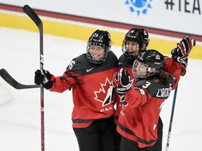 Rebecca Johnston (6), Brianne Jenner (19) and Jocelyne Larocque (3) of Canada celebrate winning the game against the United States in overtime on December 3, 2017 at Xcel Energy Center in St Paul, Minnesota. Hannah Foslien/Getty Images