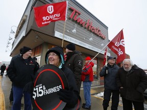 Protesters gather outside the Tim Hortons store on Monaghan Rd. on Wednesday January 10, 2018 in Peterborough, Ont. demanding that the corporation not roll back workers' wages and benefits. CLIFFORD SKARSTEDT/PETERBOROUGH EXAMINER