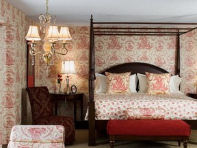 A high-impact bedroom is transformed into a hedonistic suite by draping it in dramatic fabrics and French wallpaper.