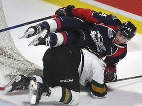 Nathan Staios of Windsor Spitfires tumbles over Nathan Dunkley of the London Knights during their OHL game in Windsor on Thursday night. (DAN JANISSE/Postmedia News)