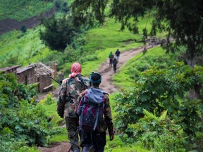 A picture taken on June 3, 2012 shows two rebels of the mutinous armed force known as M23 walking towards one of their positions on Kavumu hill in North Kivu. (Getty Images)