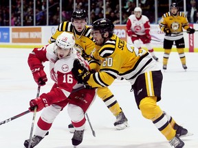 Soo Greyhounds' Morgan Frost (16) is checked by Sarnia Sting's Connor Schlichting (20) in the second period at Progressive Auto Sales Arena in Sarnia, Ont., on Friday, Jan. 19, 2018. (Mark Malone/Postmedia Network)