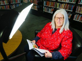 Luke Hendry/The Intelligencer
Friends of the Library member Nancy Callahan demonstrates the use of the new light-therapy lamp Tuesday.