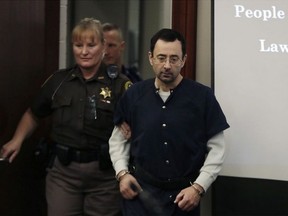 Dr. Larry Nassar is escorted into court during the seventh day of his sentencing hearing Jan. 24, 2018, in Lansing, Mich. Nassar has admitted sexually assaulting athletes when he was employed by Michigan State University and USA Gymnastics, which is the sport's national governing organization and trains Olympians. Carlos Osorio / AP