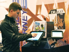 Jamie Dilliott, precision ag specialist with Kearney Planters, demonstrates how monitoring technology can be used by farmers during the Chatham-Kent Farm Show on Wednesday. Tom Morrison/Chatham This Week