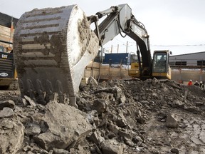 Chris Larocque of L-82 uses his big reach to scrape together a load of clay that will make up yet another load of fill taken out of the newest Tricar construction project at 40 York Street. (MIKE HENSEN, The London Free Press)