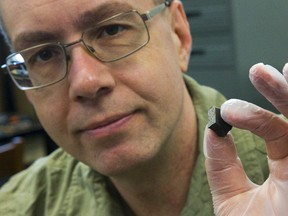 Peter Brown, a Western University meteor scientist, holds a fragment of a meteorite in his lab. Western scientists believe fragments of a meteor likely dropped from the sky northeast of Grand Bend Wednesday evening. (MIKE HENSEN, The London Free Press)