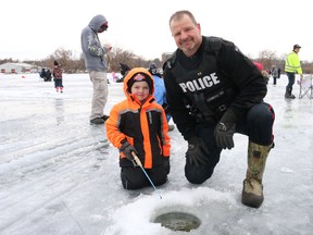 Bruce Bell/The Intelligencer
Const. Pat Comeau of the Belleville Police Service gives five-year-old Jaxson Porter a hand during Saturday’s 2nd Annual Cops & Kids Ice Fishing Derby on the Bay of Quinte.