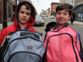 Austin Suschouten, 10, and Dylan Van Dusen, 12, handed out backpacks full of supplies to the less fortunate on Saturday. (Steph Crosier/The Whig-Standard/Postmedia Network)