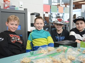 From the left, St. Jopseh students Harper Peach, 9, Kallum Larsen, 10, Austin Coté, 9, and Anthony El tawil, 9, hold a bake sale to raise funds for the Canadian Cancer Society on Jan. 24 (Peter Shokeir | Whitecourt Star).
