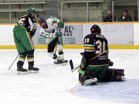 Lucan’s Brandon Jesson puts a puck on net and Thamesford Trojans’ goaltender Mitchell Van Eindhoven makes an easy save in the first period on Jan. 27. The Irish lost the game 6-2.