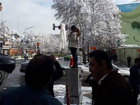 In this photo posted to Twitter, a young woman allegedly in Tehran, Iran waves her headscarf on a stick. @Amiroai / Twitter