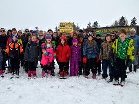 Students stand in front of parents and community members outside Sparta public school southeast of St. Thomas. Parents are fighting to reverse a decision by the Thames Valley District school board to close the school in June and open a French immersion school in September.  (Louis Pin/Times-Journal)