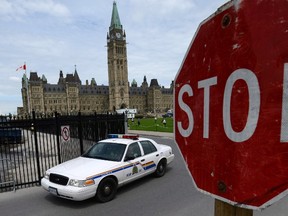 An RCMP cruiser drives past a stop sign on Parliament Hill in Ottawa on June 13, 2013. THE CANADIAN PRESS/Sean Kilpatrick