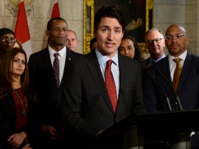 Prime Minister Justin Trudeau speaks with media during an availability in the foyer with his caucus on Parliament Hill, in Ottawa on Tuesday, January 30, 2018. THE CANADIAN PRESS/Adrian Wyld