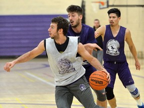 Western Mustang forward Marko Kovac is guarded by forward Daniil Shesterinin and guard Henry Tan during practice at Thames Hall. MORRIS LAMONT/THE LONDON FREE PRESS